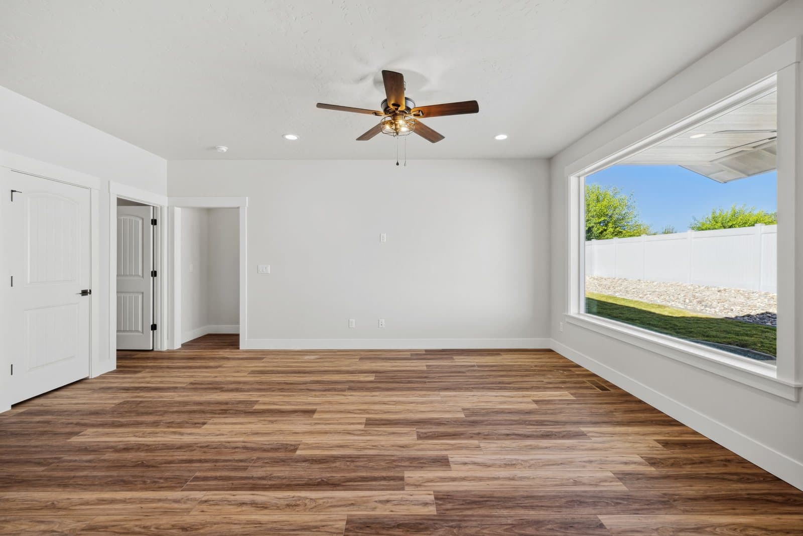 Living room with ceiling fan and wood-look floors in an Old's Ferry home
