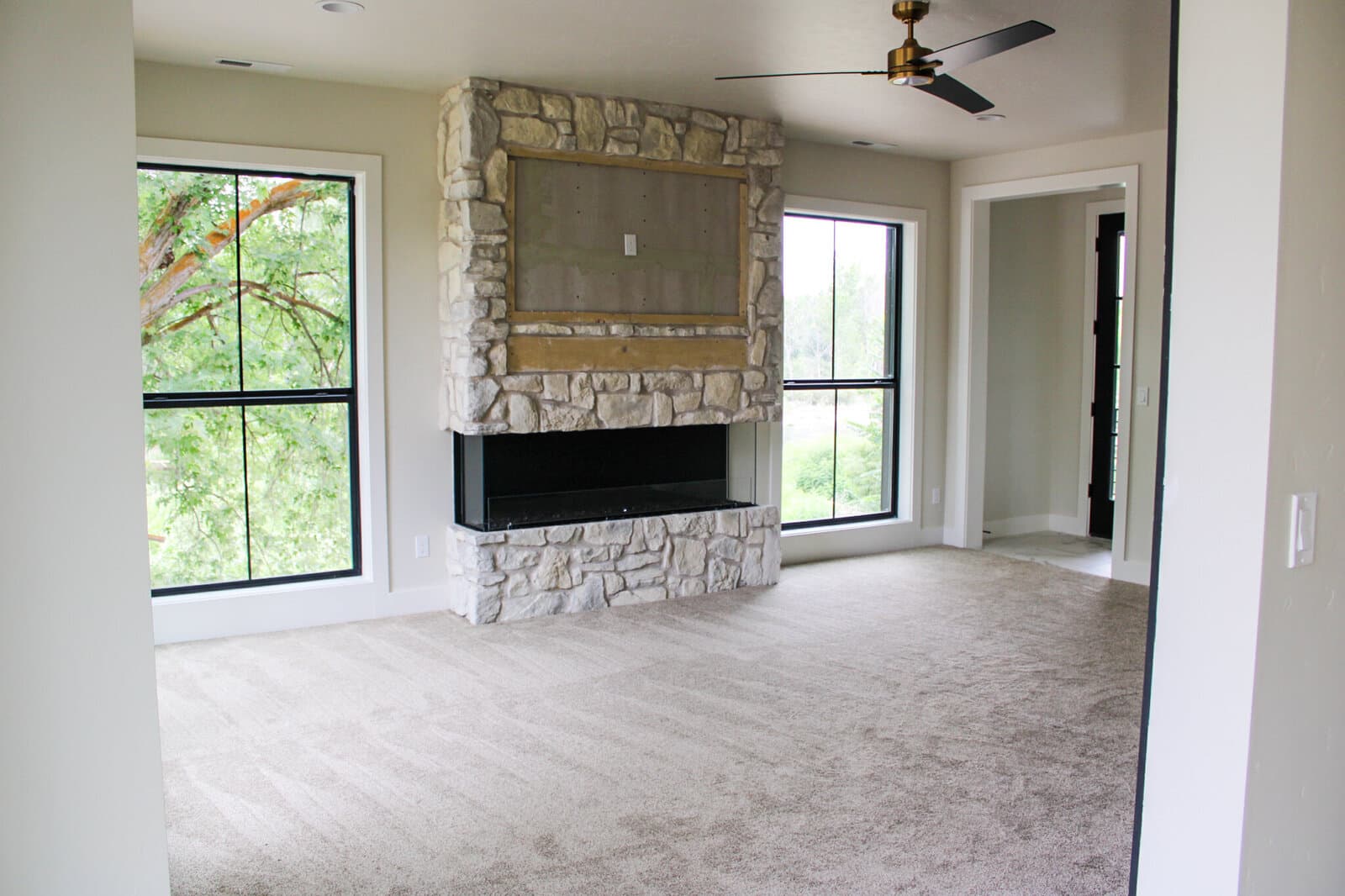 Great room with a stone fireplace in a custom home
