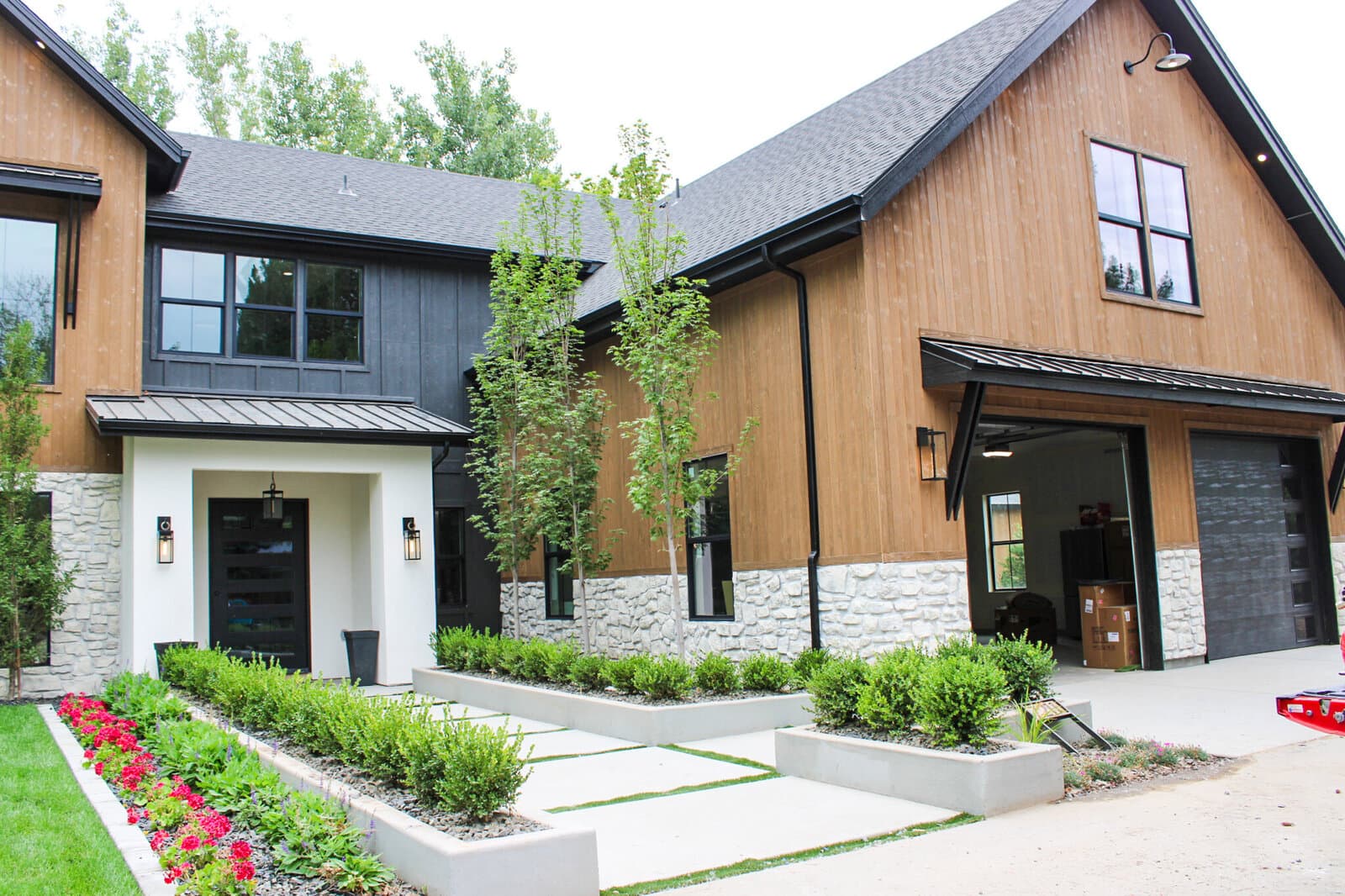 Finished custom home with landscaping and a stone-and-wood exterior